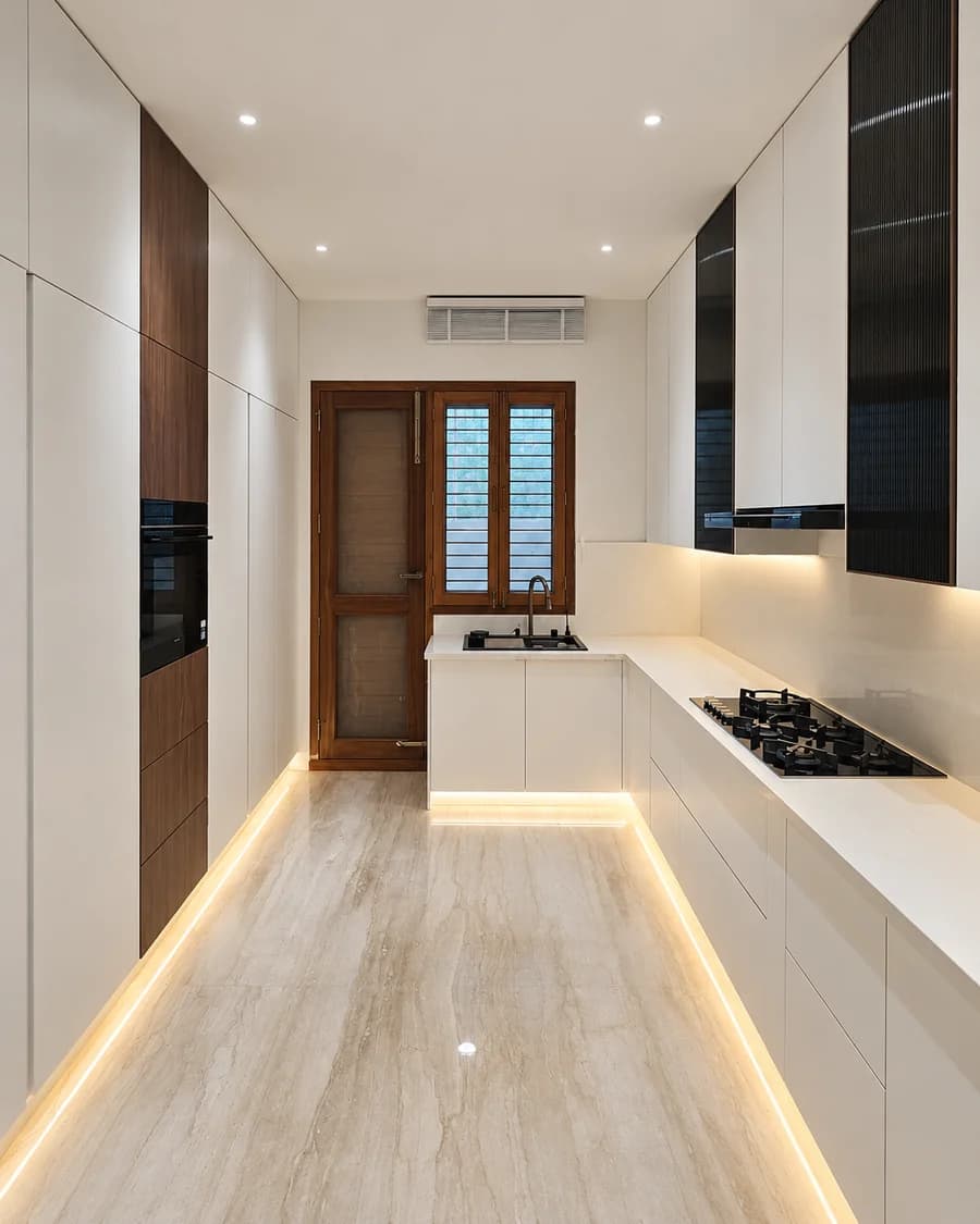 Contemporary white PU kitchen with warm veneer accents and integrated lighting.