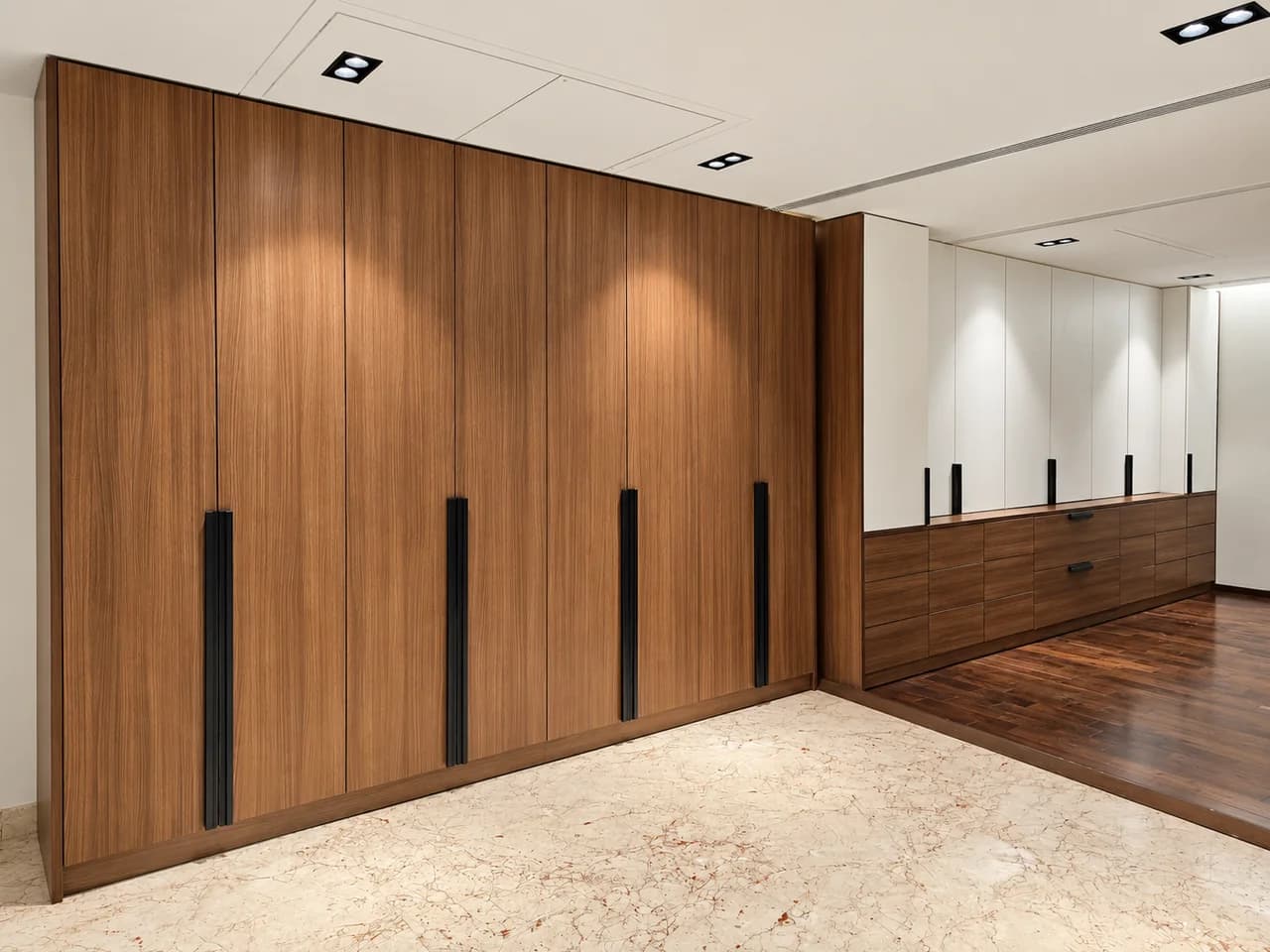 Walnut-and-white full-height wardrobe with integrated drawer storage.