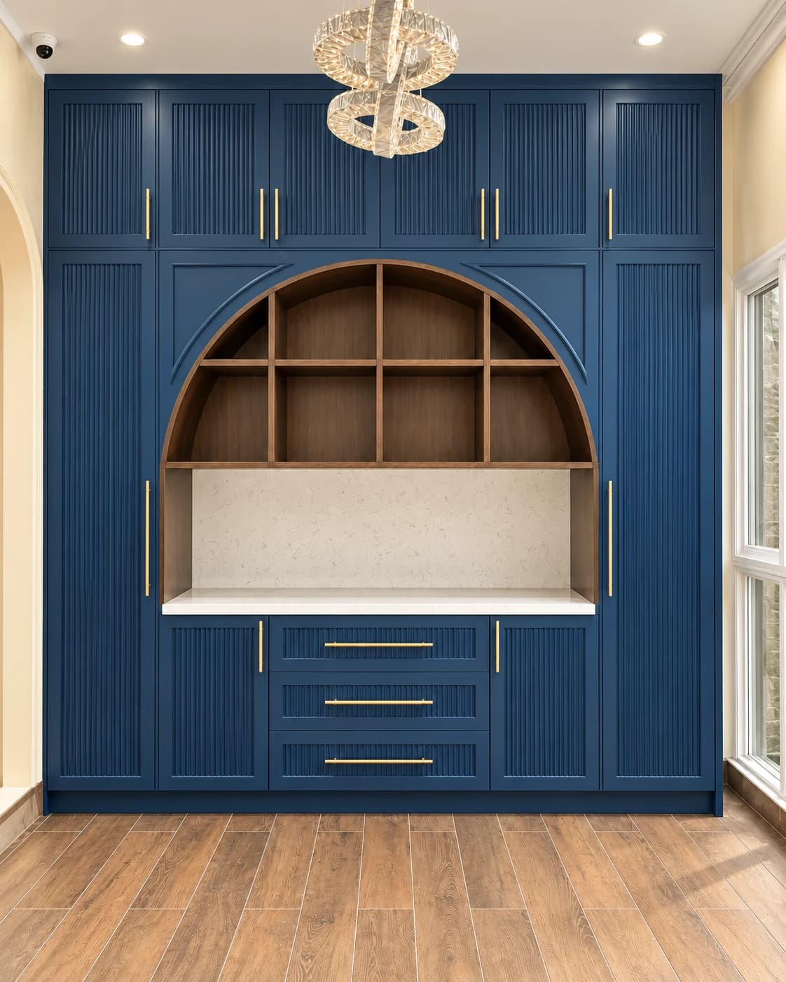 Completed navy cabinetry with fluted shutters and an arched display niche.